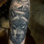 Dans la peau de ce jeune homme, une œuvre de l'encre prend vie. Un loup réaliste, fier et mystérieux, fixe l'horizon avec ses yeux perçants.