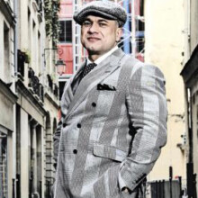 Dans son costard moitié dandy, moitié voyou...