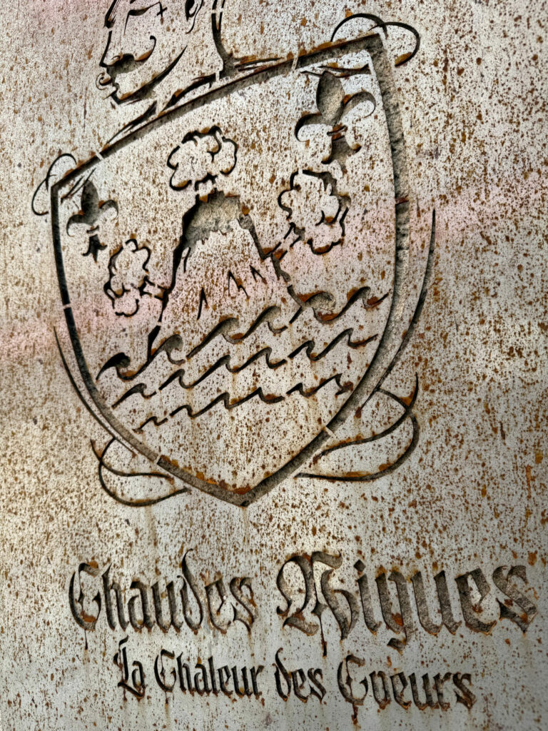 Blason Maison Chaudesaigues avec la devise « La chaleur des cœurs », inspiré de l’identité territoriale de Chaudes-Aigues et de l’univers volcanique auvergnat
