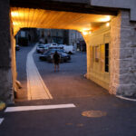 Porche ancien éclairé à Chaudes-Aigues, passage couvert menant à la place du marché et soulignant l’entrée du cœur du village.