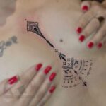 Tatouage ornemental fin en noir, placement sternum, réalisé par Tamara Chaudesaigues