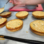 Préparation des pains briochés du burger Double G avec sauce pickles en cuisine