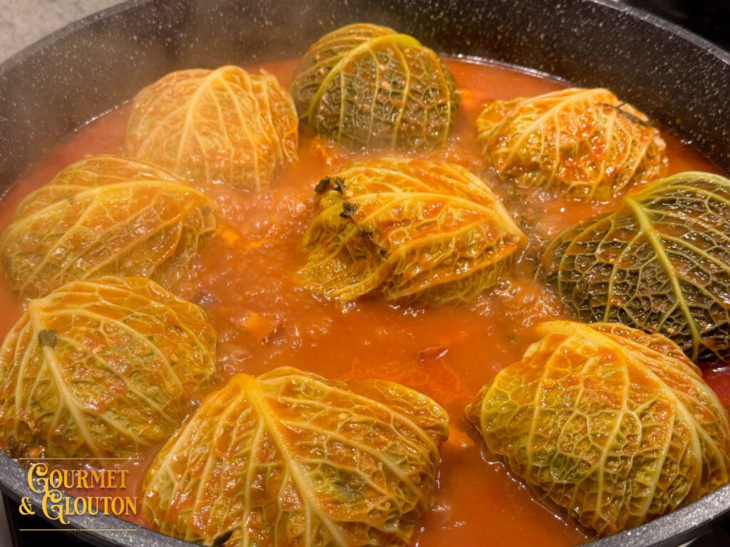 Choux farcis en cuisson dans leur sauce tomate au restaurant Gourmet & Glouton