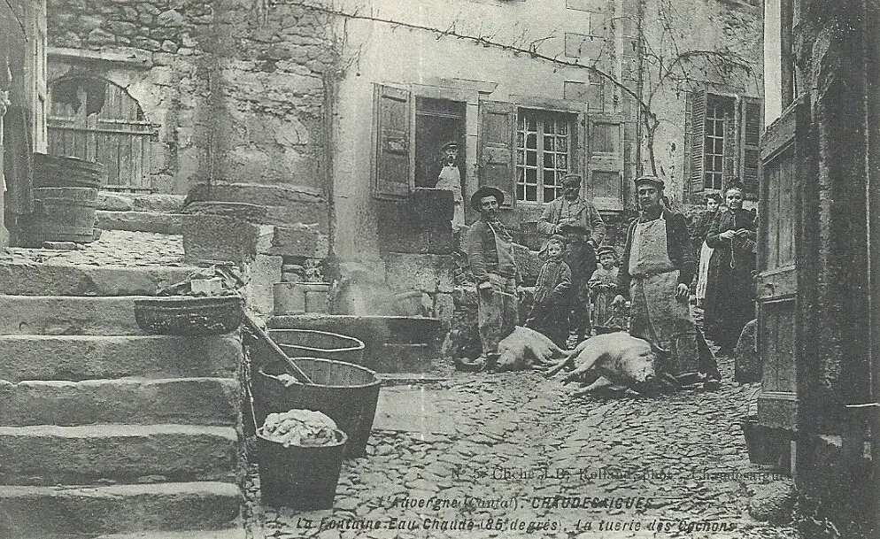 Bouchers utilisant l'eau chaude de la Source du Par pour préparer des cochons dans le quartier du Par à Chaudes-Aigues au début du XXe siècle.