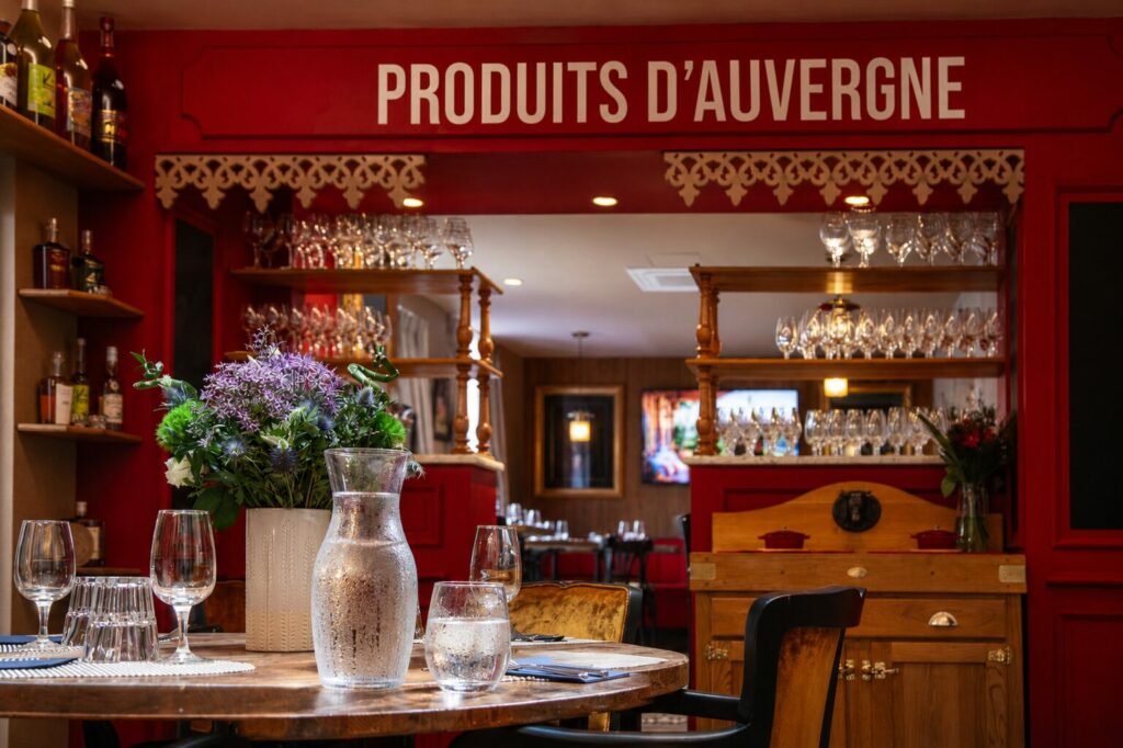 Carafe d'eau fraîche et verre d'eau sur une table de Gourmet & Glouton, restaurant entièrement climatisé à Chaudes-Aigues.