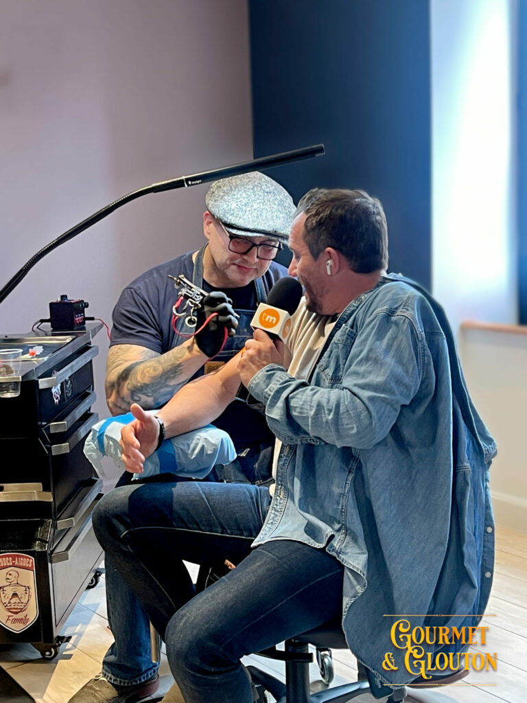 Stéphane Chaudesaigues réalise un tatouage sur Loïc Ballet lors d'un reportage tourné à Chaudes-Aigues.