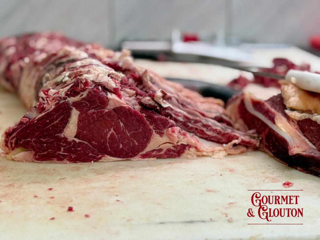 Faux-filet de Black Angus française en cours de préparation chez Gourmet & Glouton à Chaudes-Aigues, mettant en valeur le persillage naturel de cette viande d'exception.