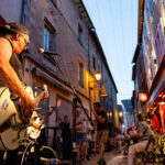 Le guitariste de Cadillac Rumble joue rue Notre-Dame d’Août pendant les Terrasses Musicales chez Gourmet & Glouton à Chaudes-Aigues.