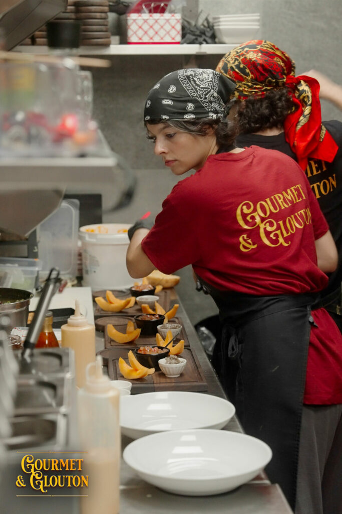 Équipe de cuisine de Gourmet & Glouton préparant les assiettes à Chaudes-Aigues durant l’été 2026